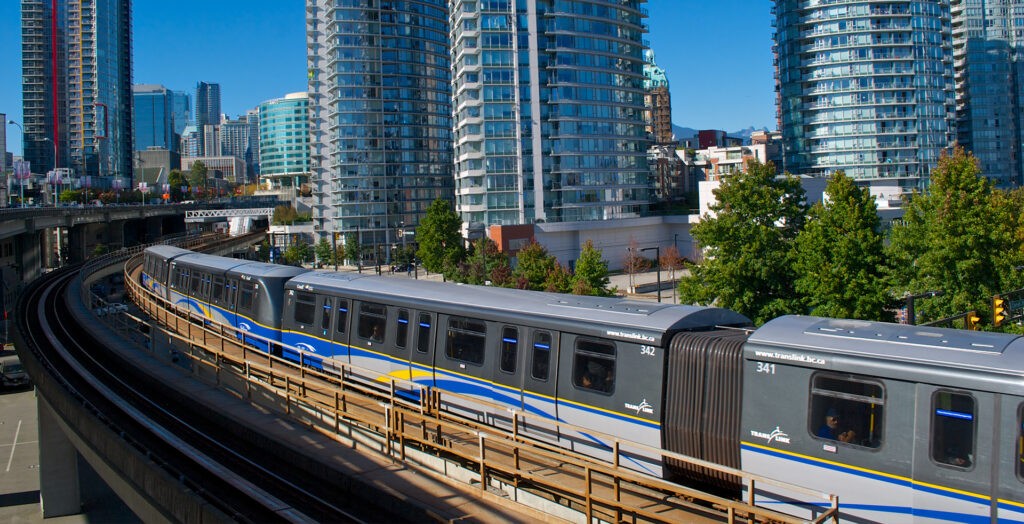 A SkyTrain moves Eastbound, having just exited Stadium-Chinatown Station in Vancouver, BC.