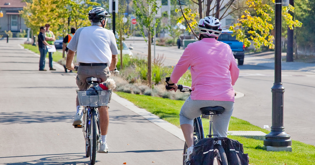 Two seniors biking on a fully separated bike lane.