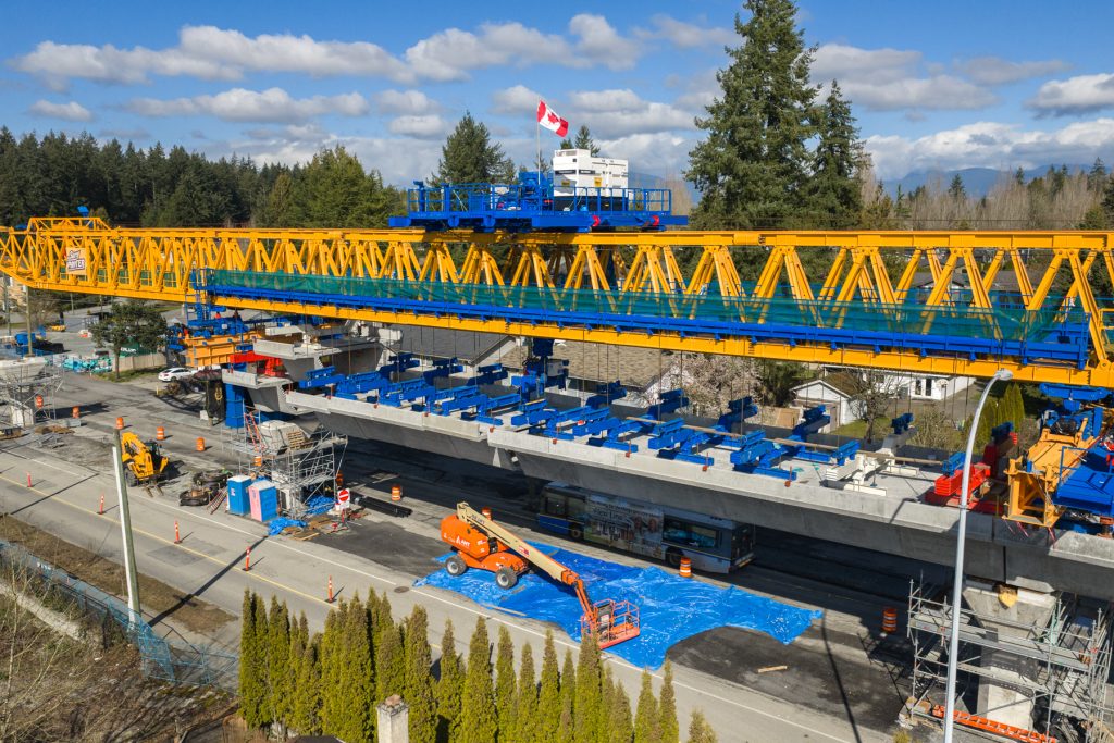 An image of the Surrey Sprinter launching gantry lifting segments to build the elevated guideway.