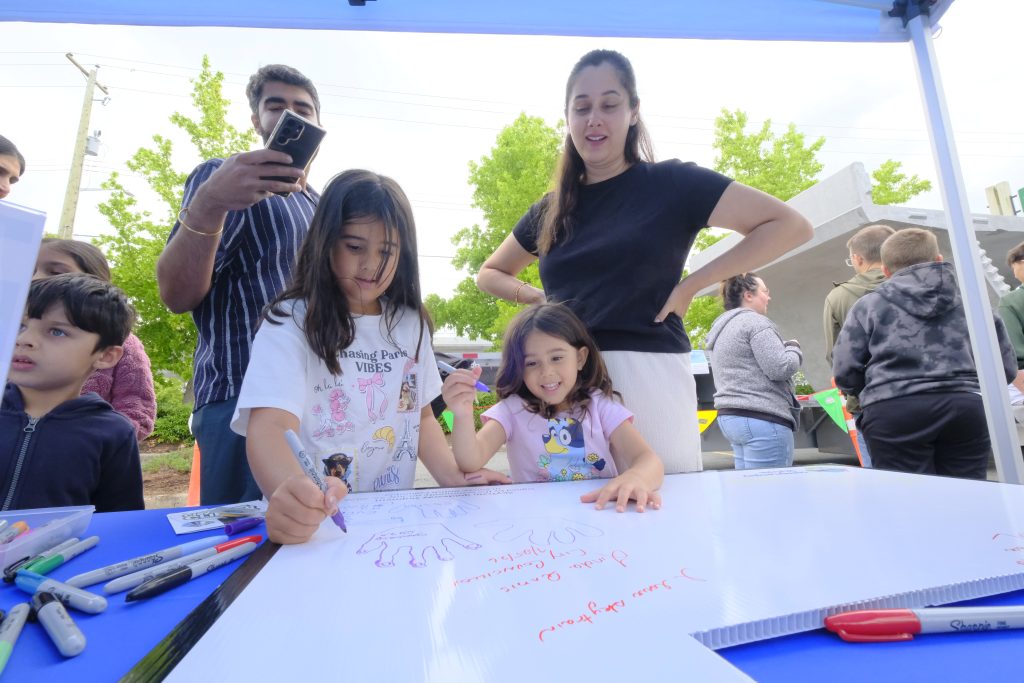 Two children sign the segment board.
